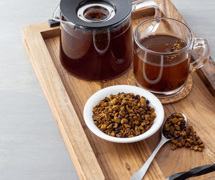 Chaga tea in a mug with tea kettle