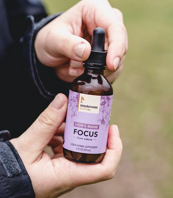 man holding focus tincture by mushroom revival