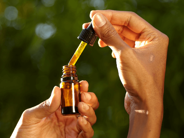 woman holding medicinal mushroom tincture bottle